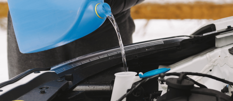 Заливка зимней омывающей жидкости в бачок омывателя автомобиля.